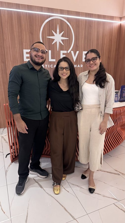 Jade com a equipe da Elleve em frente ao letreiro da clínica