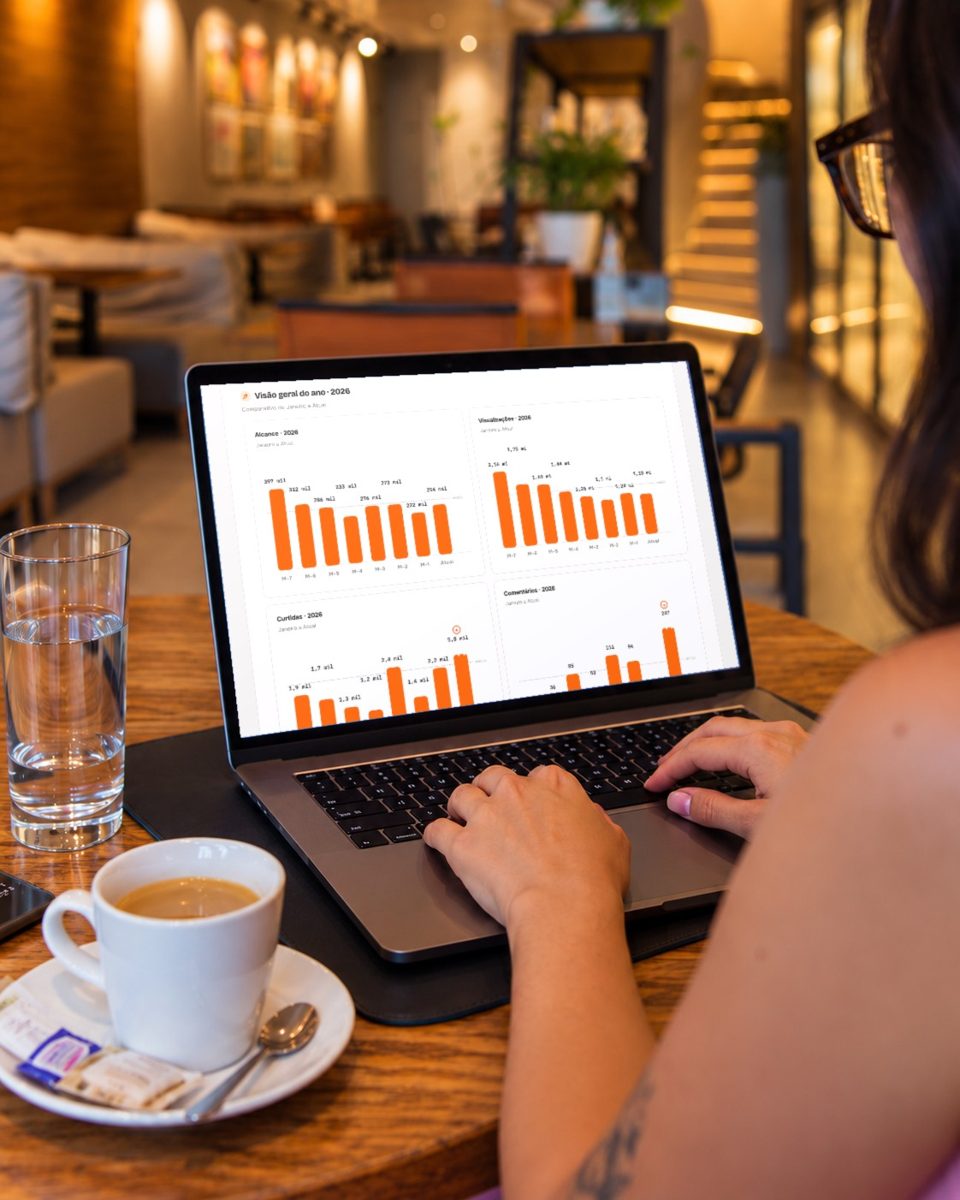 Pessoa trabalhando num café com o relatório da Abacaxi aberto no notebook